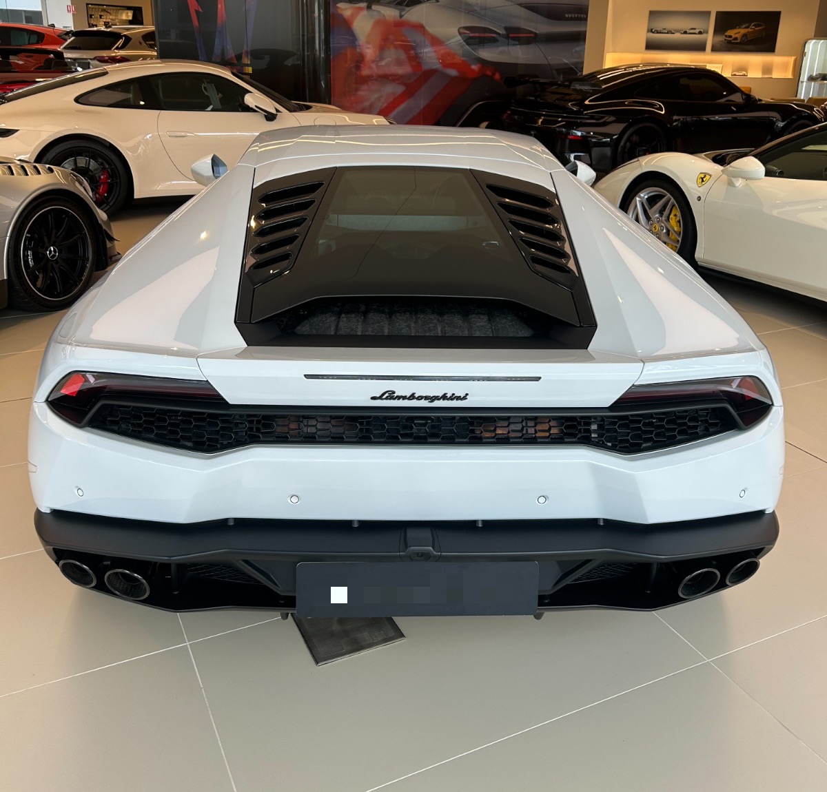 A Huracán in white, photographed by us at Lamborghini's Sydney showroom, flanked by a GT3 RS and a 488. Photography: Queen of Cars; number plate blurred per our privacy policy.